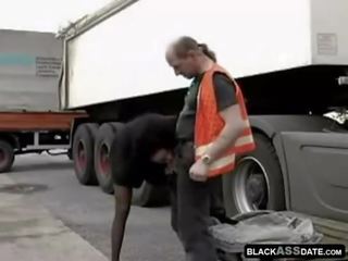 Black streetwalker riding on mature truck driver outside