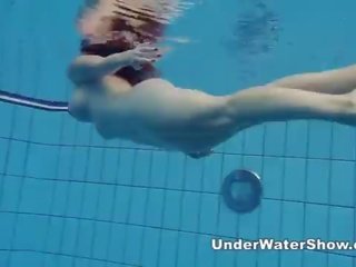 Redheaded bukuri duke notuar lakuriq në the pishinë